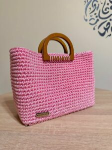 Couffin rose en crochet fait main, base et anses en bois, par Sola. Tunisie